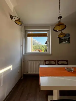 a dining room with a table and a window at APARTMA CARPE DIEM in Kranjska Gora