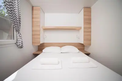a small bedroom with two beds and a window at Mediteran Travel Mobile Homes in Camping Terme Čatež in Brežice