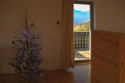 a christmas tree in a room with a window at Magical Family Home 84 in Bohinj
