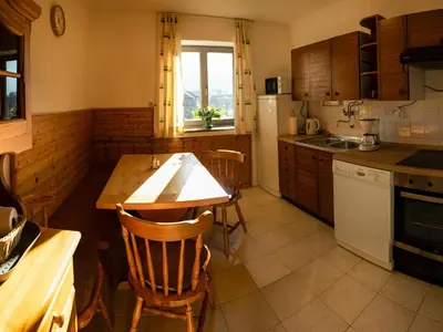 a kitchen with a wooden table and a table and chairs at Magical Family Home 84 in Bohinj