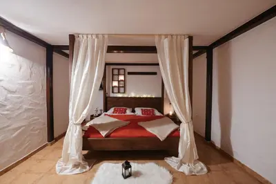 a bedroom with a red bed with red pillows at Wellness Holiday House Lagev in Moravske Toplice