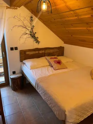 a bed in a bedroom with a wooden ceiling at Wellness Holiday House Lagev in Moravske Toplice