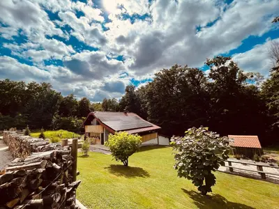 a farmhouse with a fence and trees in a yard at Wellness Holiday House Lagev in Moravske Toplice