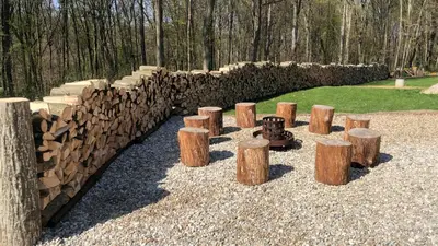 a pile of logs sitting next to a stone wall at Wellness Holiday House Lagev in Moravske Toplice