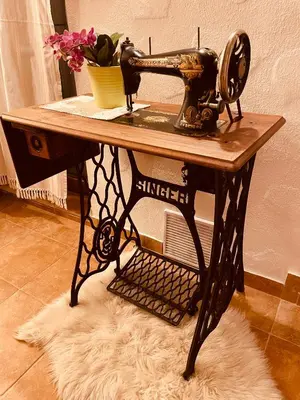 an old sewing machine on a table with flowers on it at Wellness Holiday House Lagev in Moravske Toplice