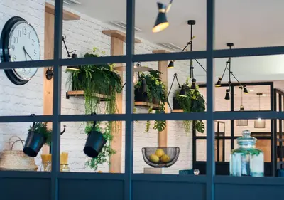 a room with a window with potted plants and a clock at Urban Ring Hotel in Ljubljana