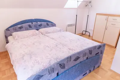 a bed in a bedroom with a blue bed frame at House Parabola in Log pod Mangartom