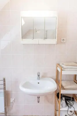 a bathroom with a sink and a mirror at House Parabola in Log pod Mangartom