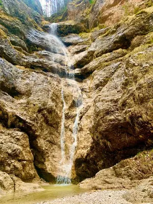 a waterfall on the side of a rocky mountain at House Parabola in Log pod Mangartom