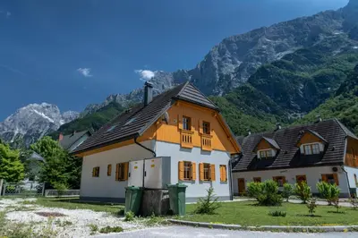 a large house with mountains in the background at House Parabola in Log pod Mangartom