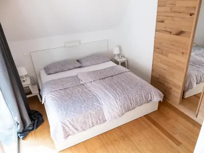 a bedroom with a white bed and a mirror at D&N Apartment in Ljubljana