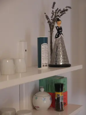 a shelf with a figurine of a woman and a vase at D&N Apartment in Ljubljana