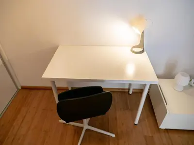 a white desk with a chair and a lamp at D&N Apartment in Ljubljana