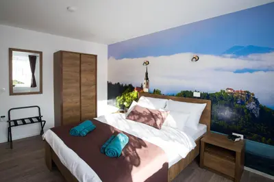 a bedroom with a large bed with a painting on the wall at ALEX BUMBLEBEE in Bled