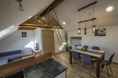 a dining room and living room with a table and chairs at Apartma Marička in Križe