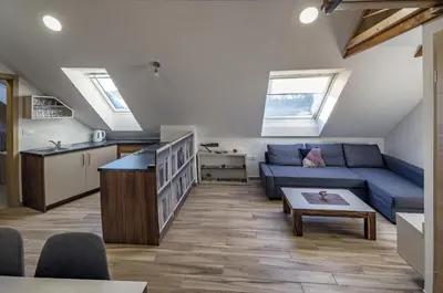 a living room with a blue couch and a kitchen at Apartma Marička in Križe