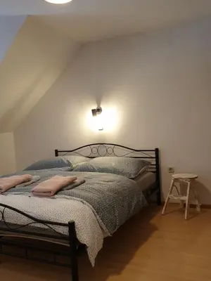 a bedroom with two beds and a light on the wall at Apartment Barje I in Ljubljana