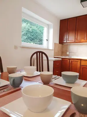 a kitchen with white bowls on a wooden table at Apartment Barje I in Ljubljana