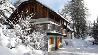 a house in the snow with snow covered trees at Chalet Harmony Rogla - apartment in Zreče