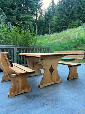 a wooden picnic table and bench on a patio at Chalet Harmony Rogla - apartment in Zreče