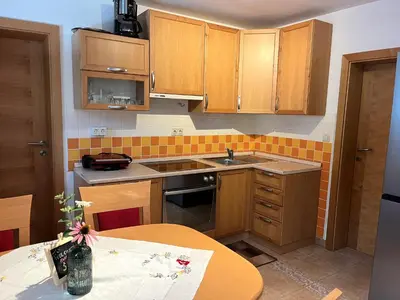 a small kitchen with wooden cabinets and a table at Chalet Harmony Rogla - apartment in Zreče