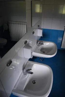a bathroom with two sinks and a mirror at Hostel Ociski Raj in Kozina