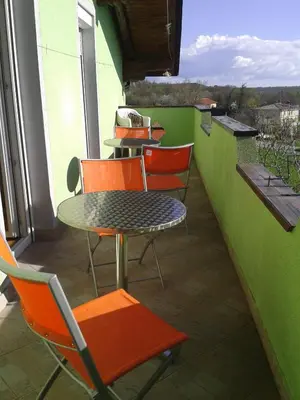 a patio with a table and chairs on a balcony at Hostel Ociski Raj in Kozina