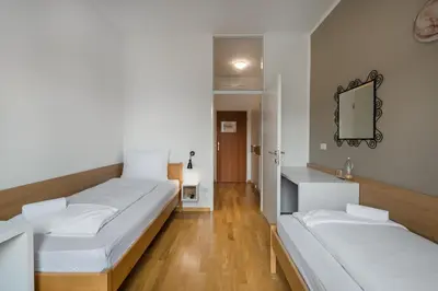 two beds in a room with a mirror on the wall at Hotel Dvorec in Tolmin