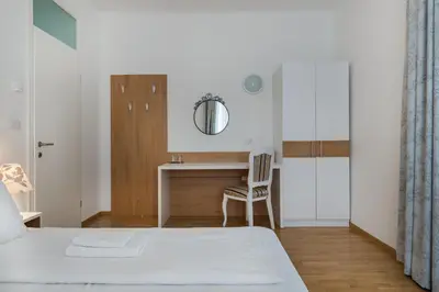 a bedroom with a bed and a desk with a mirror at Hotel Dvorec in Tolmin