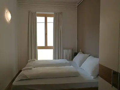 a bedroom with two beds in front of a window at Hotel Dvorec in Tolmin