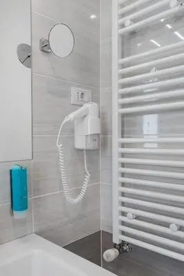 a bathroom with a shower with a phone on the wall at Hotel Dvorec in Tolmin