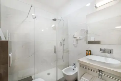 a bathroom with a shower and a toilet and a sink at Hotel Dvorec in Tolmin