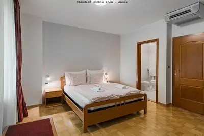 a bedroom with a bed and a bathroom at Hotel Dvorec in Tolmin