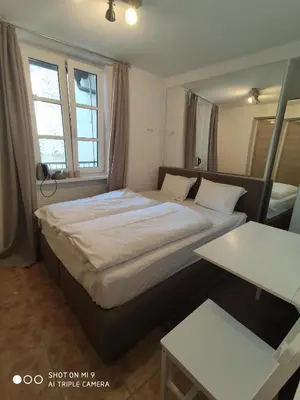 a bedroom with a large bed and a table at Aparthotel Cross Street 4 in Ljubljana