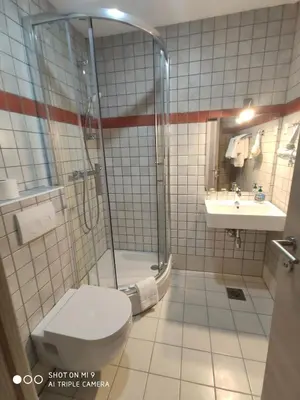a bathroom with a shower and a toilet and a sink at Aparthotel Cross Street 4 in Ljubljana