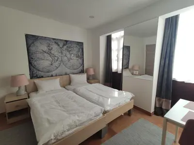 a bedroom with a large bed with white sheets at Aparthotel Cross Street 4 in Ljubljana