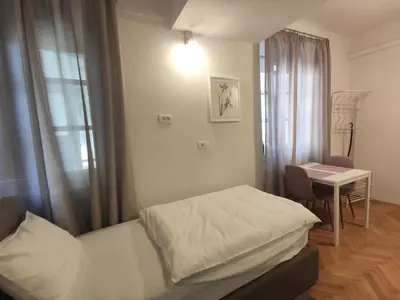 a bedroom with a bed and a table and a desk at Aparthotel Cross Street 4 in Ljubljana