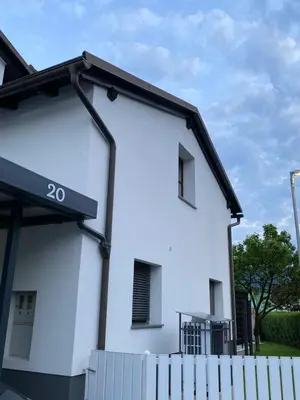 a white house with a fence in front of it at Apartma Bernard in Radovljica