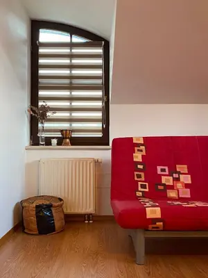 a living room with a red couch and a window at Apartma Bernard in Radovljica