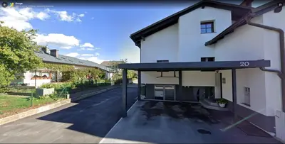 an external view of a white house with a driveway at Apartma Bernard in Radovljica