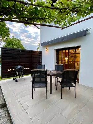 a patio with a table and chairs and a grill at Apartma Bernard in Radovljica