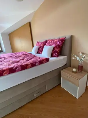a bedroom with a large bed with red pillows at Apartma Bernard in Radovljica