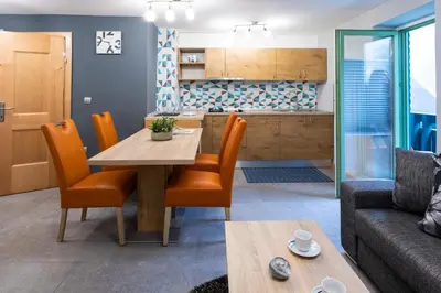 a kitchen and living room with a table and chairs at Apartma Borovnica Rogla in Vitanje