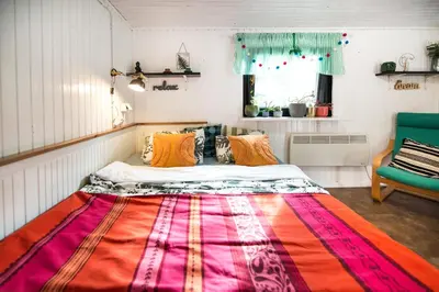 a bed in a room with a colorful blanket on the floor at Boho House 1 camp Terme Catez with promotional tickets prices in Čatež ob Savi
