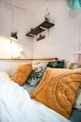 a bed with blankets and pillows in a room at Boho House 1 camp Terme Catez with promotional tickets prices in Čatež ob Savi