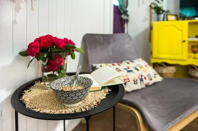a table with a vase of flowers and a book at Boho House 1 camp Terme Catez with promotional tickets prices in Čatež ob Savi