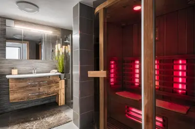 a bathroom with a sink and a shower with red lights at Panoramic View Cottage Heated Pool, Swimspa & Sauna in Pohorje