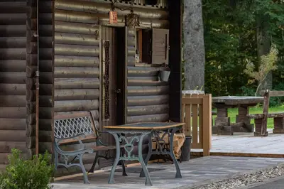 a table and chairs sitting outside of a cabin at Cabin Storzek in Pohorje