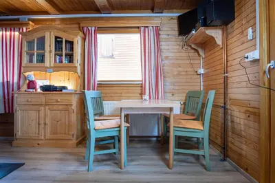 a kitchen with a table and chairs and a window at Cabin Storzek in Pohorje