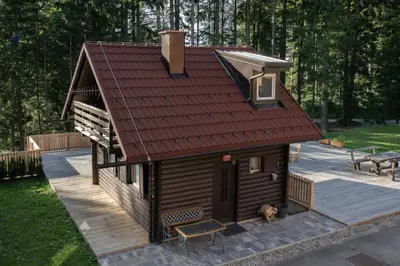 a small cabin with a red roof on a patio at Cabin Storzek in Pohorje